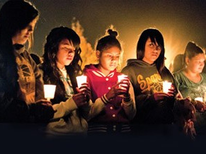 Young mourners holding candles at a vigil in Sparks